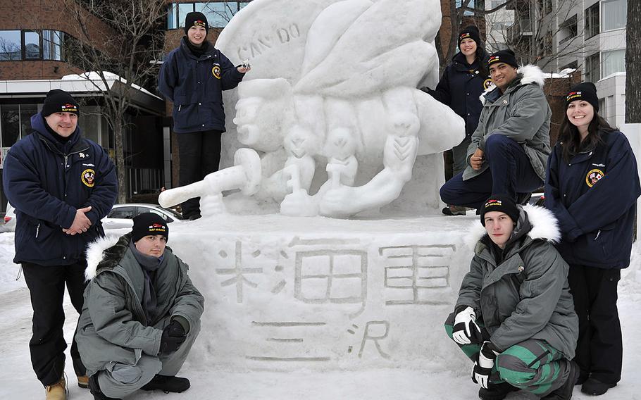 The 2014 Navy Misawa Snow Team poses on Feb. 3, 2014, with the "Fighting Bee" snow sculpture they completed for the 65th Annual Sapporo Snow Festival. The sculpture is a tribute to the U.S. Navy Seabees, who are celebrating their 72nd anniversary this year.