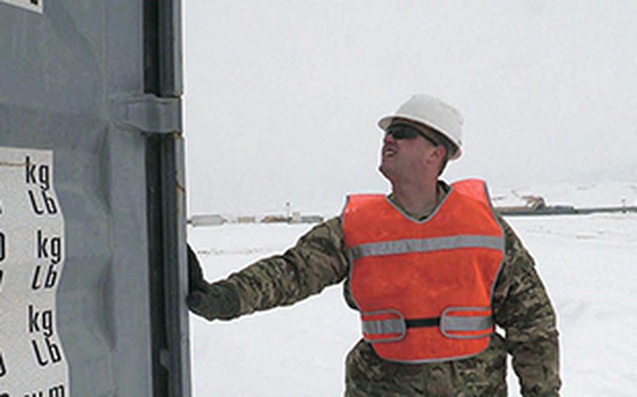 Chief Petty Officer Aaron Borg, with the U.S. Coast Guard Redeployment Assistance and Inspection Detachment team, inspects the outside of a U.S. Army shipping container in northern Afghanistan in February 2014 to  determine whether it is worthy to be shipped by sea, or should be scrapped and recycled.