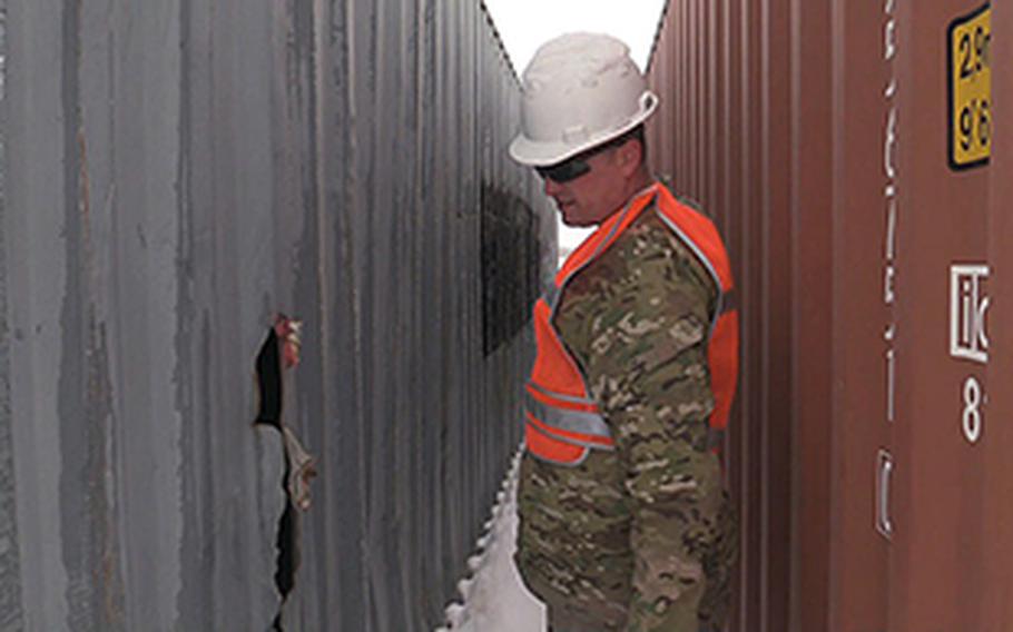 Chief Petty Officer Aaron Borg, with the U.S. Coast Guard Redeployment Assistance and Inspection Detachment team inspects the outside of a U.S. Army shipping container at Camp Marmal in Mazar-e-Sharif, Afghanistan in February 2014.