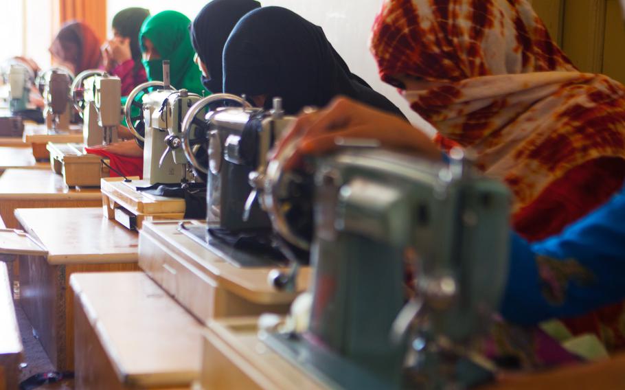A group of Afghan women use sewing machines to make clothing at the Department of Women's Affairs office in Lashkar Gah, Helmand province, Afghanistan, July 2013. The women attend vocational schools at the DoWA to learn skills that will help them earn an income and financially support their families.