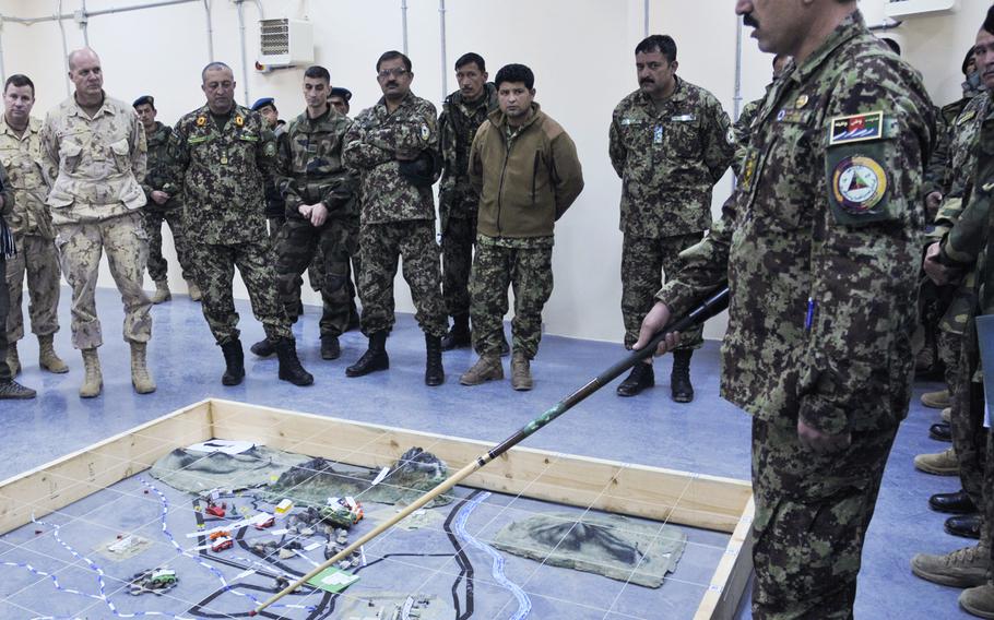 Maj. Gen. Dean Milner, commanding general, NATO Training Mission-Afghanistan, far left, and Afghan Maj. Gen. Mohammad Habib Hessary, observe Afghan National Army soldiers practicing battlefield tactics at the Consolidated Fielding Center in Kabul, Afghanistan on Feb. 20, 2014.