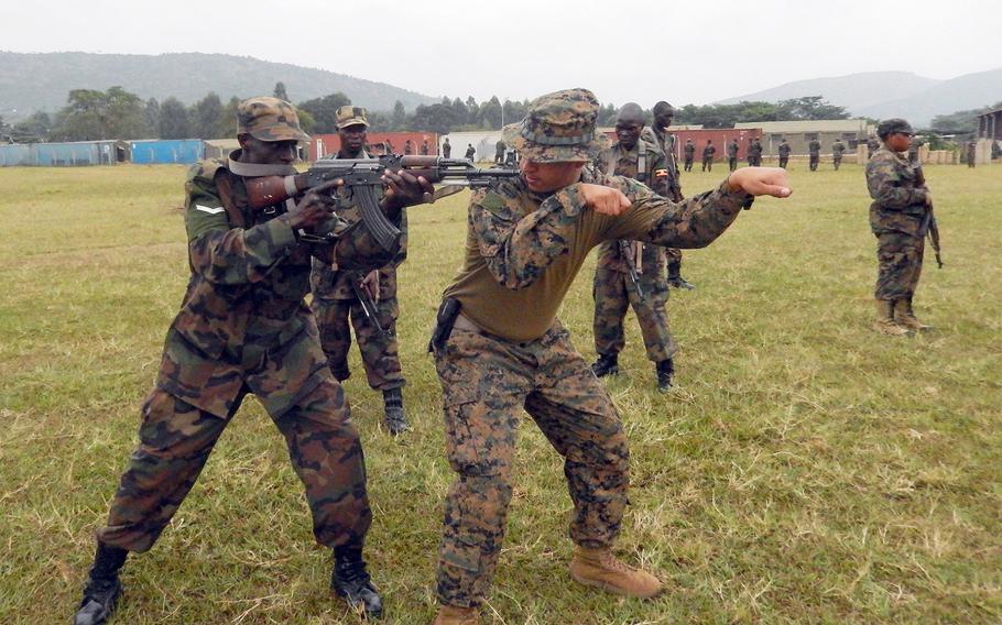 A Marine with Special-Purpose Marine Air-Ground Task Force Africa 13 demonstrates a proper shooting stance to a Uganda People's Defense Force Soldier during a combat marksmanship class aboard Camp Singo, Uganda, on July 31, 2013.