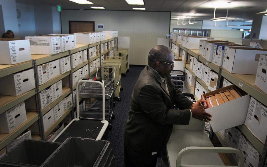Douglas Bragg, the director of the Veterans Benefits Administration office in Oakland, Calif., looks into one of the many boxes that contain the cases of veterans with pending claims, April 18, 2013. 