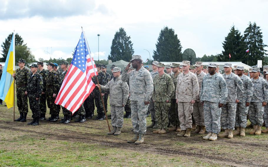 U.S. Air Force Col. Christopher Brooks, U.S. Delegation Chief for the United States, reports in during the opening ceremony of Combined Endeavor 2013.