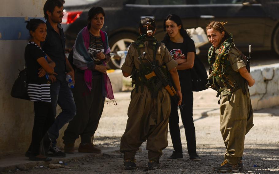 Zekia Karhan, 26, far-right, and Felice Budak, 24, third from right, visit with their a few of their male Kurdistan Workers' Party counterparts in Makhmur, Iraq, on Aug. 23, 2014.