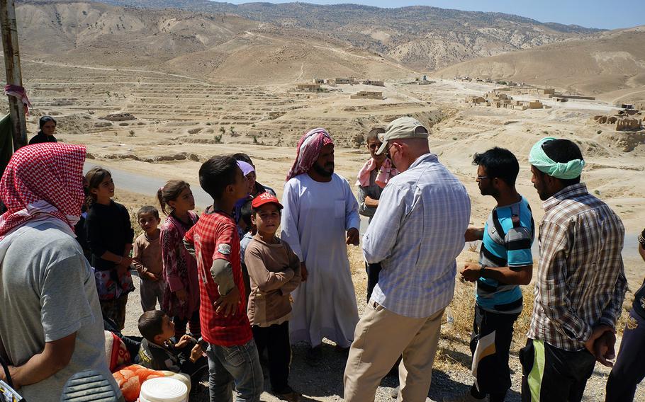 A member of the U.S. Mount Sinjar Assessment Team talks with locals near Sinjar, Iraq, on Aug. 13, 2014. 