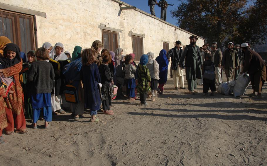 Afghan girls from the all girls school in the Narang District, Konar province, Afghanistan, receive school and other supplies donated by the U.S. from the Narang District sub-governor in this Dec. 2007 photo.