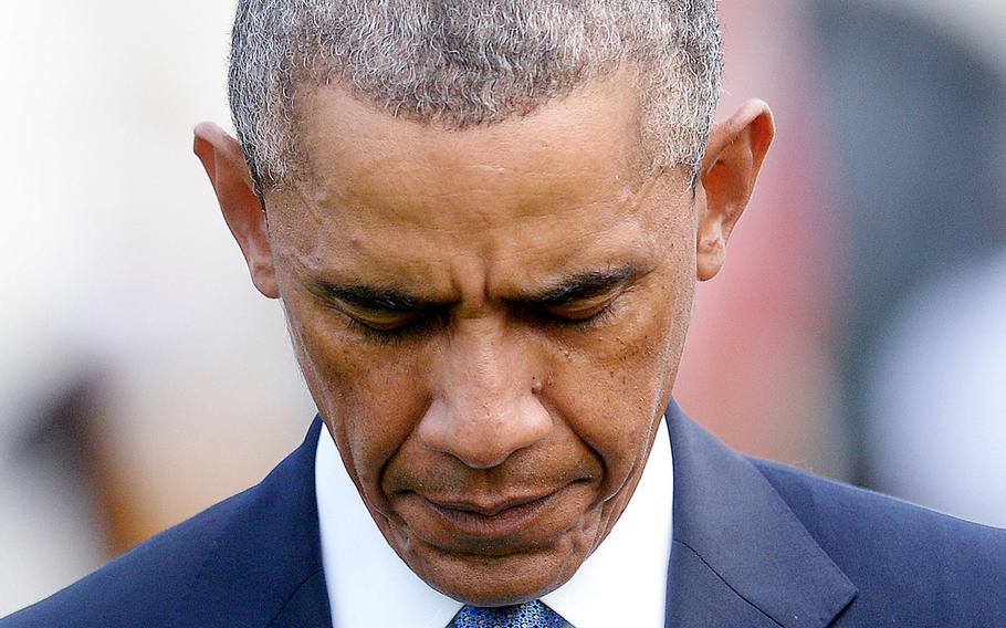 U.S. President Barack Obama observes a moment of silence to mark the 13th anniversary of the 9/11 attacks on Thursday, Sept. 11, 2014, on the South Lawn of the White House in Washington, D.C. 