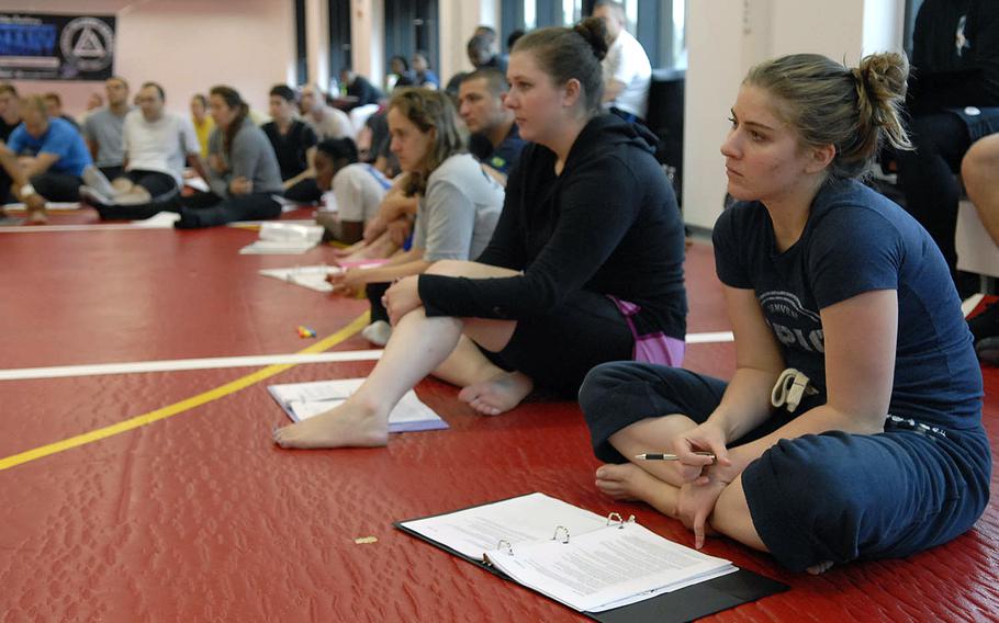 Students sit and listen during a self-defense class held Thursday, Sept. 4, 2014, at Ramstein Air Base, Germany. Instructors from the Gracie Jiu-Jitsu Academy taught the four-day program, intended to help participants get certified to teach self-defense in their communities.