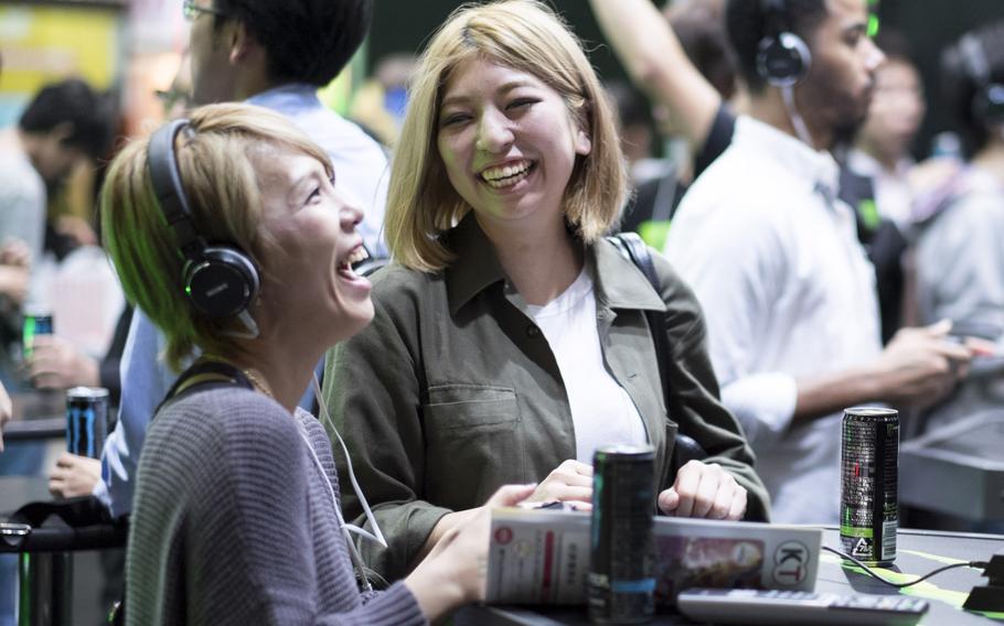 Two women play video games at the Monster Energy Drinks booth at the Tokyo Game Show Sept. 18, 2014, in Makuhari, Japan.