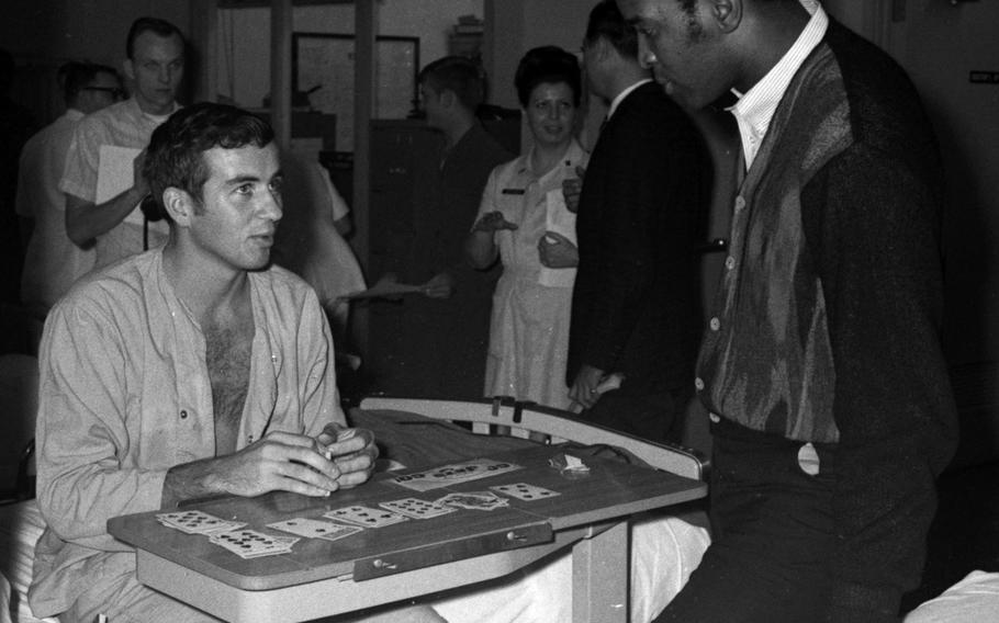 Marv Fleming of the Green Bay Packers talks with a servicemember at the U.S. Army Hospital on Camp Oji, Japan, in January, 1969.