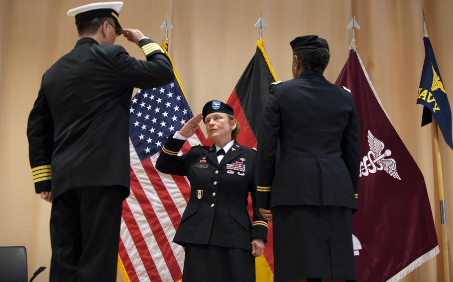Col. Judith Lee, commander of Landstuhl Regional medical Center, salutes Navy Capt. Donald Sze during a transfer-of-authority ceremony Friday, Sept. 26, 2014, that saw the inactivation of the Navy Expeditionary Medical Unit, which had been at the hospital since 2006.