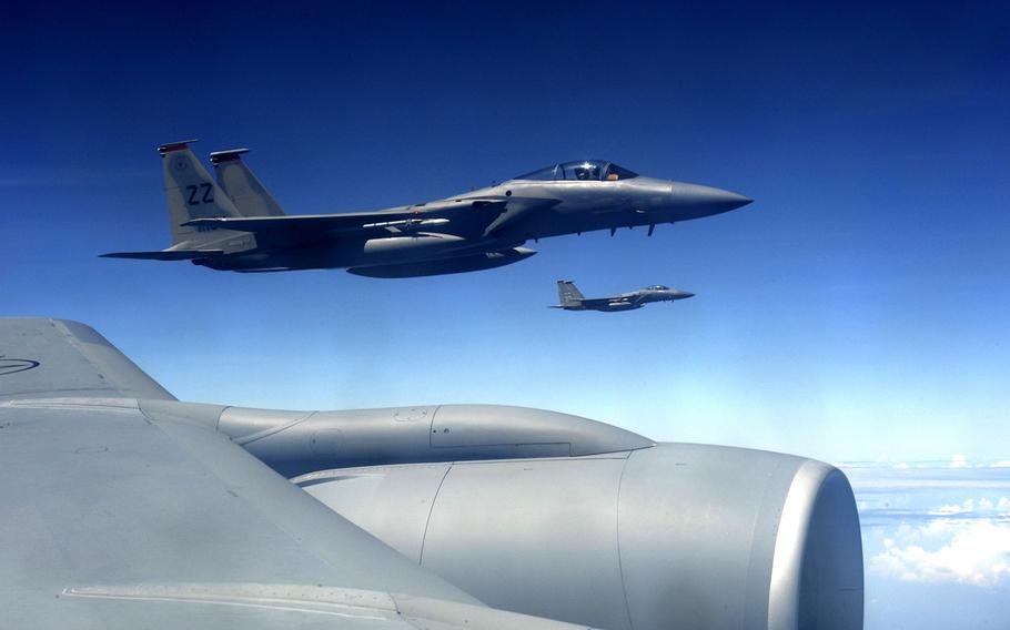 Two U.S. Air Force F-15 Eagles from the 67th Fighter Squadron fly in formation alongside a KC-135 Stratotanker aerial refueling aircraft over the Pacific Ocean as they return to Kadena Air Base, Japan, Oct. 29, 2013.