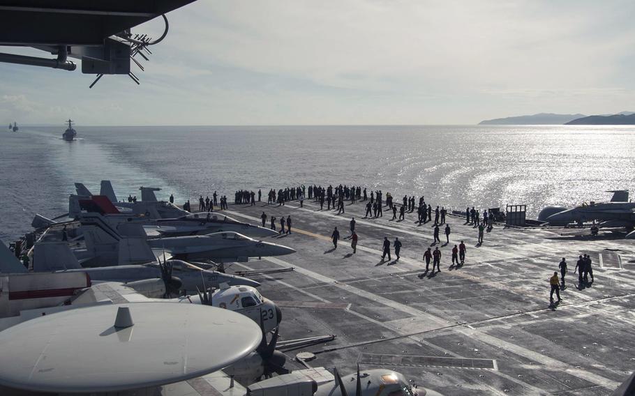 Sailors observe the Philippine Islands from the flight deck of the Nimitz-class aircraft carrier USS Carl Vinson  during a transit through the Siargao Strait on Sept. 27, 2014.