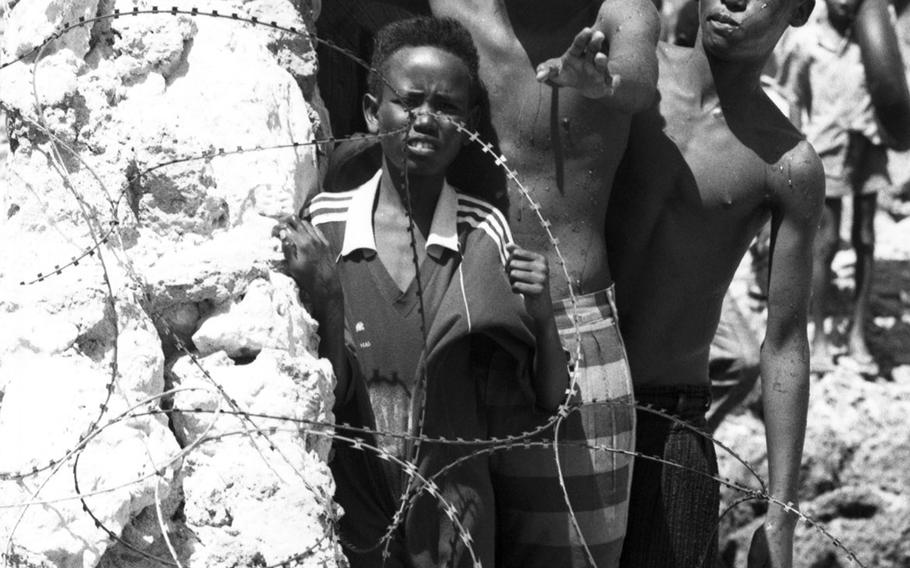 Young Somalis stand behind the razor wire at the edge of a U.S. compound in Mogadishu.