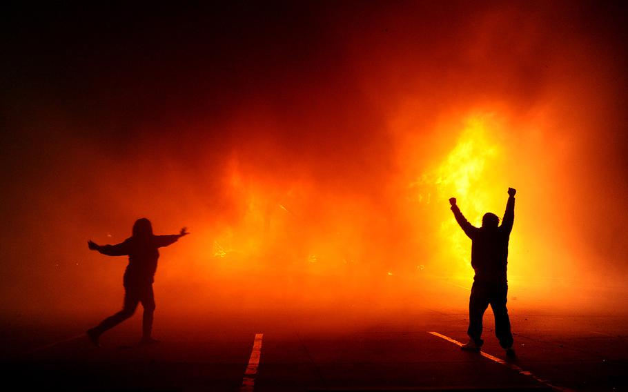 Protesters celebrate as the Auto Zone building burns on West Florissant Avenue on Nov. 24, 2014, after the Ferguson grand jury decision was announced.