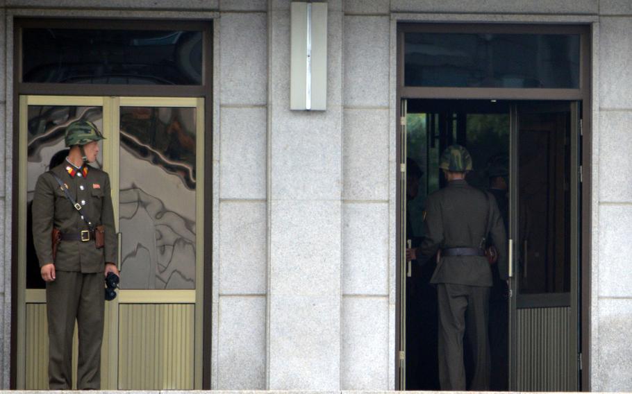 A North Korean soldier watches fellow soldiers enter in Panmungak building at the Joint Security Area, North Korea, July 27, 2013.