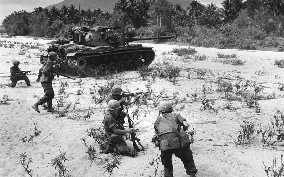 Troops move up with a tank ahead of them during fighting in the An Lao Valley in 1967.