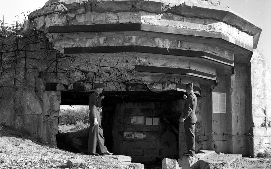 Master Sgt. William J. Hopkins Jr. and Master Sgt. George C. Zares, who took part in the Normandy invasion in 1944, look over destroyed German fortifications ten years later.