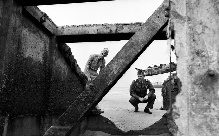 Master Sgt. William J. Hopkins Jr. and Master Sgt. George C. Zares, who took part in the Normandy invasion in 1944, look over destroyed German fortifications ten years later.