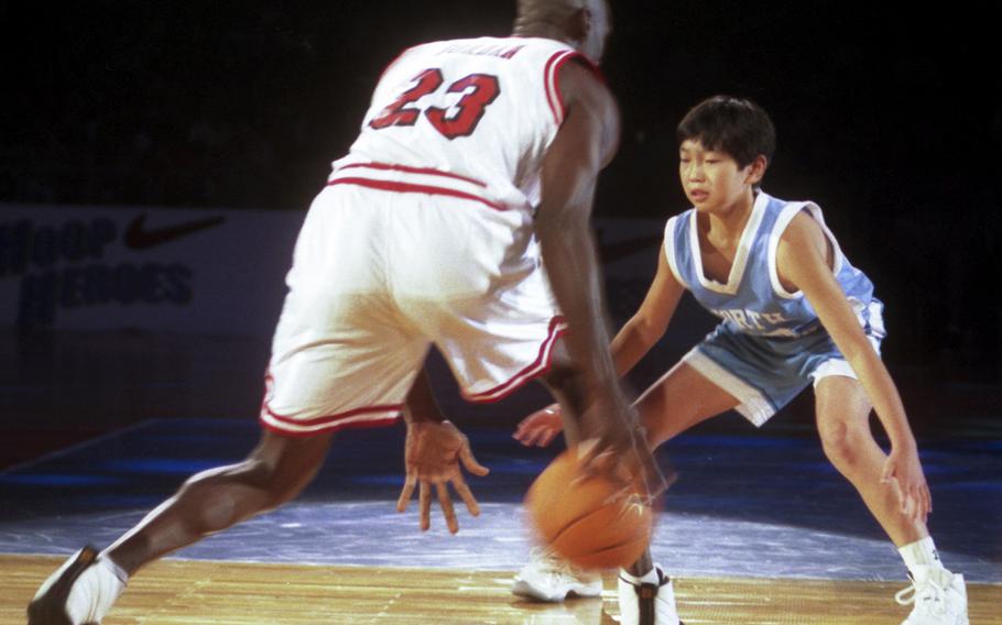 Ten-year-old Keijuro Matsui tries to defend against Michael Jordan during a one-on-one game at a 1996 basketball clinic in Tokyo.
