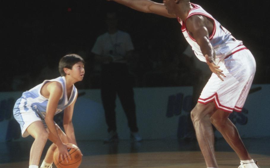 Ten-year-old Keijuro Matsui tries to find a way around Michael Jordan during a one-on-one game at a 1996 basketball clinic in Tokyo.