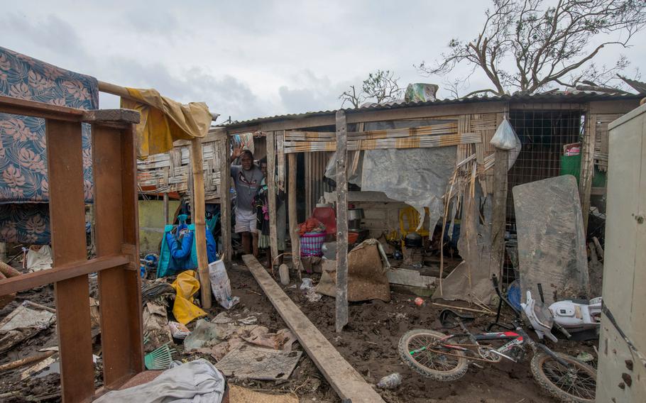 In this March 15, 2015, photo provided by UNICEF Pacific, residents stand inside damaged house after Cyclone Pam struck Mele village, on the outskirts of the capital Port Vila, Vanuatu.
