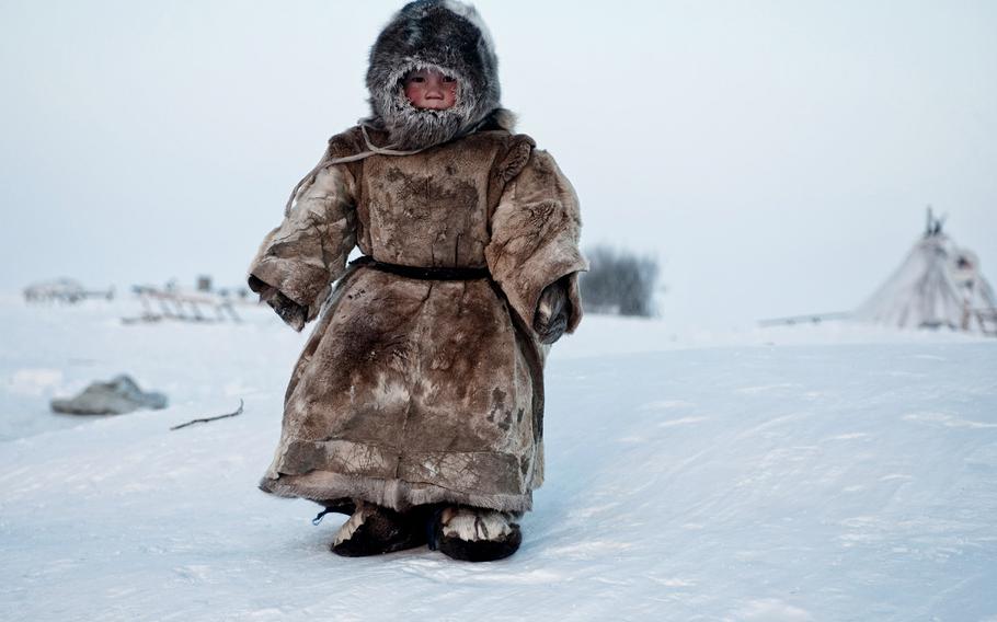 Simon Morris, "On the Tundra..." | A Young Nenets boy plays in -40 degrees on Yamal in the Winter in Siberia.