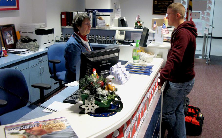 Twyla Hirrilinger, a volunteer at the USO lounge at Baltimore-Washington International Airport, greets Marine Corps Pfc. Zachary Haase as he arrives at the lounge during holiday travel Dec. 23, 2009.
