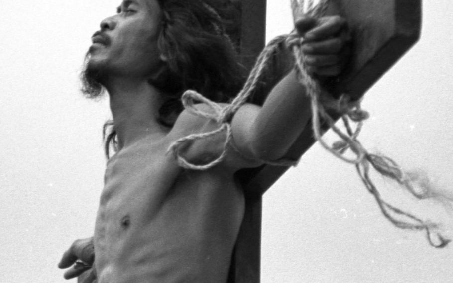 A Filipino man grimaces in pain from the six-inch spikes driven into his hands and feet during the annual Good Friday reenactment of the crucifixion of Christ at San Fernando, Pampanga Province, Philippines, in April, 1985.