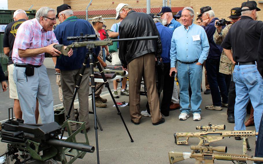 A Marine reconnaissance veteran checks out a modern sniper rifle Thursday, April 23, 2015, at Camp Pendleton, Calif. About 175 Vietnam-era recon vets reunited at Camp Pendleton for a commemoration of the 50th anniversary of the beginning of the Vietnam War.