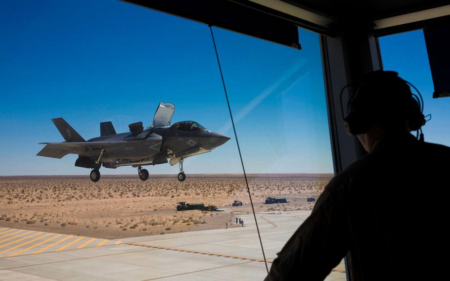 An F-35B Lightning II with Marine Fighter Attack Squadron 121 at Marine Corps Air Station Yuma, Ariz., performs a vertical landing while an air traffic controller observes from a mock air control tower at an auxiliary landing field, Monday, April 27, 2015. The landing field simulates an aircraft carrier flight deck.