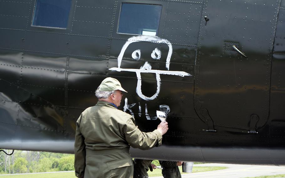 A member of the Texas Flying Legends Museum paints Kilroy Was Here on a plane at the Culpeper Regional Airport Thursday, May 7, during the preview for the Arsenal of Democracy: World War II Victory Capitol Flyover.