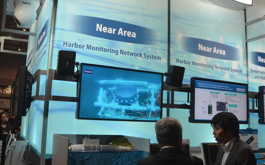 Attendees discuss a harbor monitoring system at a pavilion at the MAST conference in Yokohama, Japan, Wednesday, March 13, 2015. The three-day conference included the U.S. 7th Fleet, the Japan Self-Defense Force and military officials from around the world.

