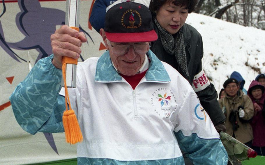 Louis Zamperini carries the Olympic torch in Japan in 1998.