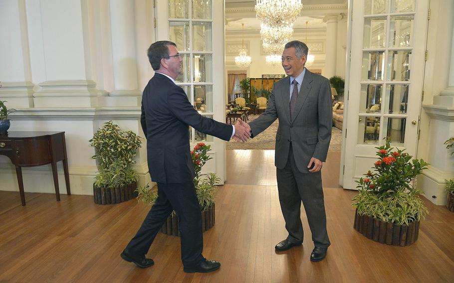 U.S. Secretary of Defense Ash Carter shakes hands with the Prime Minister of Singapore Lee Hsien Loong as they prepare to meet, on Friday May 29, 2015.