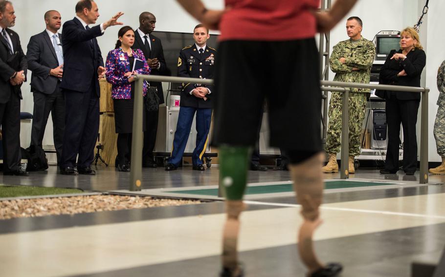 Department of Veterans Affairs Secretary Bob McDonald, left, talks with Vice Chairman of the Joint Chiefs of Staff Adm. James A. Winnefeld, Jr., right, during a wounded warrior demonstration at the Military Performance Lab during a tour of the Center for the Intrepid, Dec. 19, 2014.
