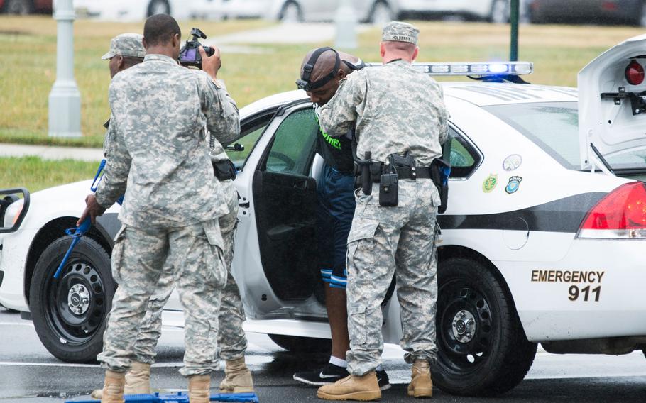 In this file photo from Sept. 25, 2014, a role-player portraying an active shooter is detained by security personnel during an exercise at Joint Base Myer-Henderson Hall, Va.