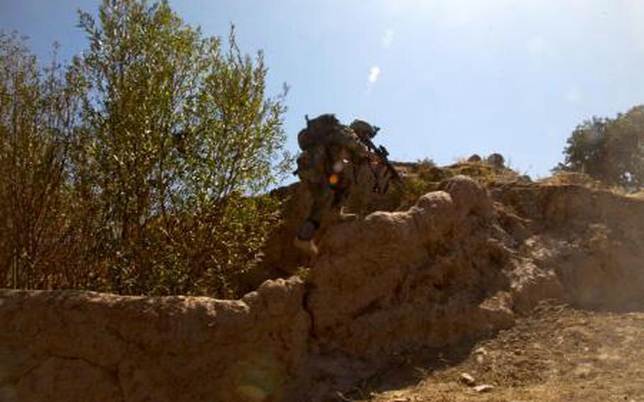 An Afghan special operator with the 5th Commando Kandak climbs a wall to gain high ground during a clearing operation Qairsar district, Faryab province, Afghanistan, Sept. 20, 2011. 