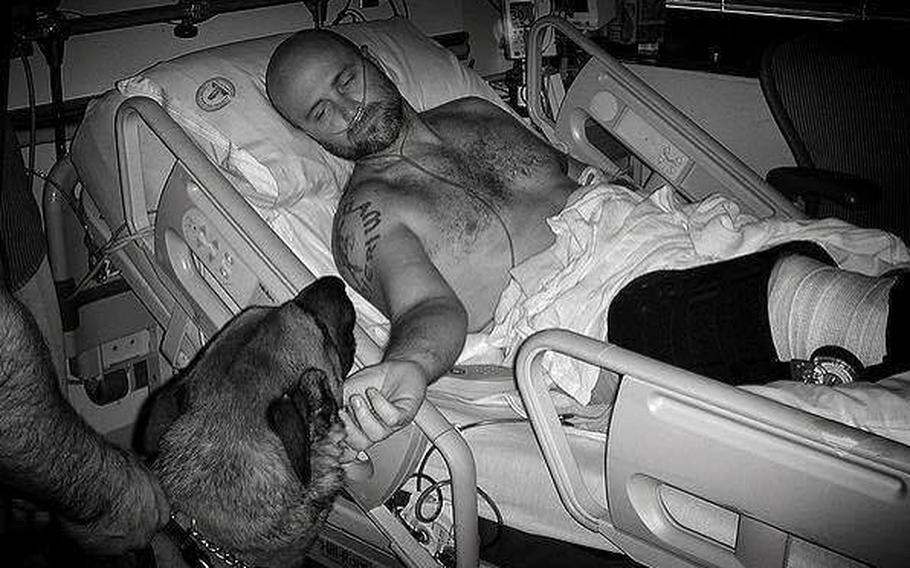 Navy SEAL James Hatch with his dog Spike, a Belgian Malinois multi-purpose canine. Hatch was severely wounded while on a mission to rescue Army Sgt. Bowe Bergdahl who left his post in Afghanistan in 2009 and has subsequently been charged with desertion and misbehavior before the enemy.