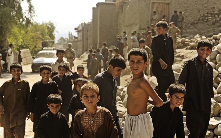 Afghan children follow coalition forces during a mentoring neighborhood patrol, Sept. 5, 2011, in Mehtar Lam, Laghman province. A report issued Monday, April 18, 2016, by the United Nations shows that Afghan children continue to lack access to necessary medical care and education. 