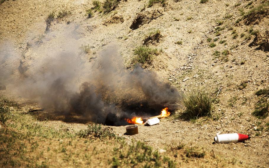 Smoke bombs emit white and black smoke to simulate detonated improvised explosive devices at a mine clearance and counter-IED.