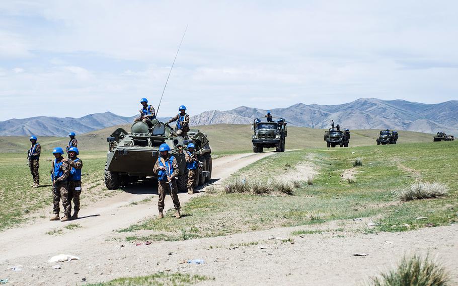 Members of the Mongolian Armed Forces detain a role player during counter-improvised explosive device. 