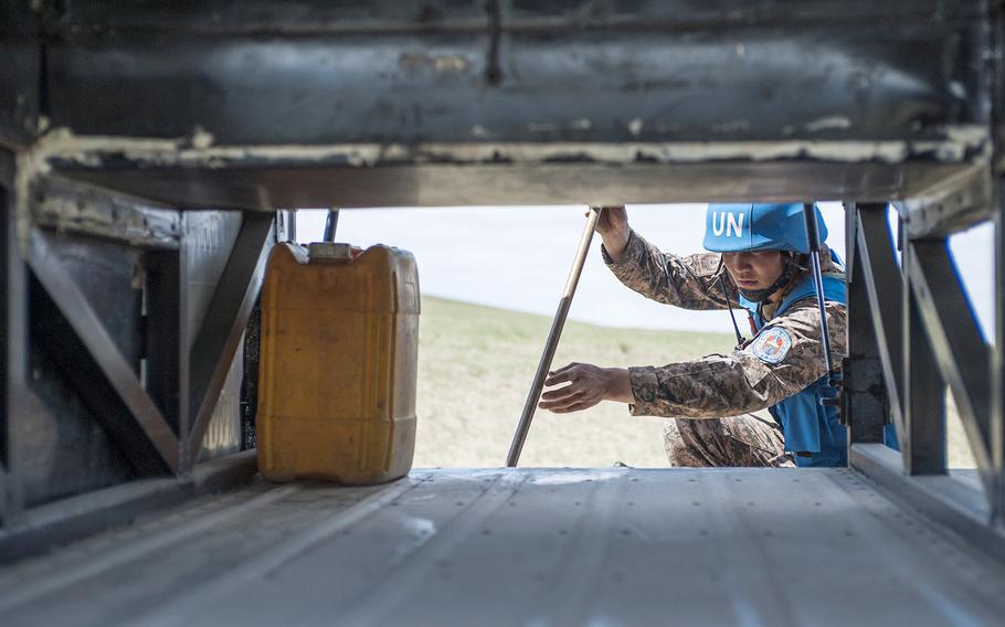 Mongolian Armed Forces inspects a bus for an improvised explosive device.