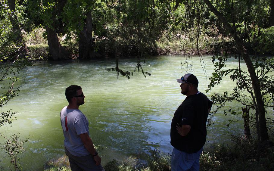 Barrett Frantzen and Jeremiah Trombly survey the Medina River following recent flooding in Bandera, Texas, on June 6, 2016.
