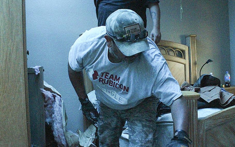 Lloyd Engle and Barrett Frantzen remove debris from a house following recent flooding in Bandera, Texas on June 6, 2016.