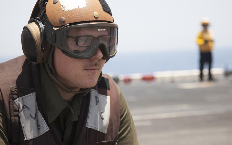 Lance Cpl. Blake Tarver, a plane captain for the 13th Marine Expeditionary Unit embarked on the amphibious assault ship USS Boxer, observes an AV-8BII Harrier prior to conducting the first aircraft sorties launched from the ship against the Islamic State in Iraq and Syria on Thursday, June 16, 2016.  
