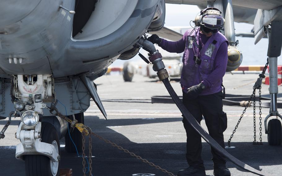 Petty Officer 3rd Class Jared Lagrimas fuels a 13th Marine Expeditionary Unit AV-8BII Harrier prior to the plane's launch from the amphibious assault ship USS Boxer on Thursday, June 16, 2016. The Harriers conducted the first airstrike sorties from the ship against the Islamic State. 