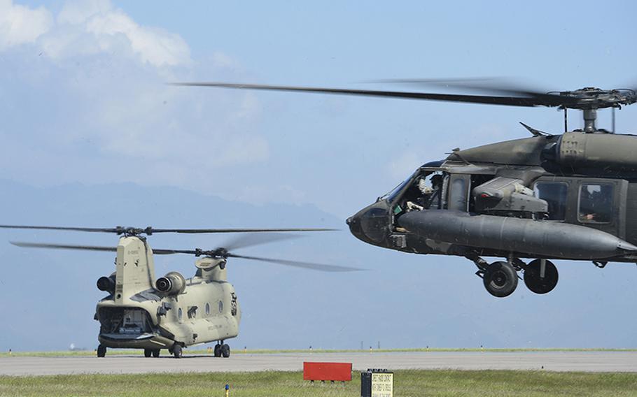 A UH-60 Blackhawk and a CH-47 Chinook helicopter prepare to launch from Soto Cano Air Base, Honduras, Oct. 4, 2016, to stage at the Grand Cayman Islands to provide airlift capabilities for Hurricane Matthew relief efforts if requested.