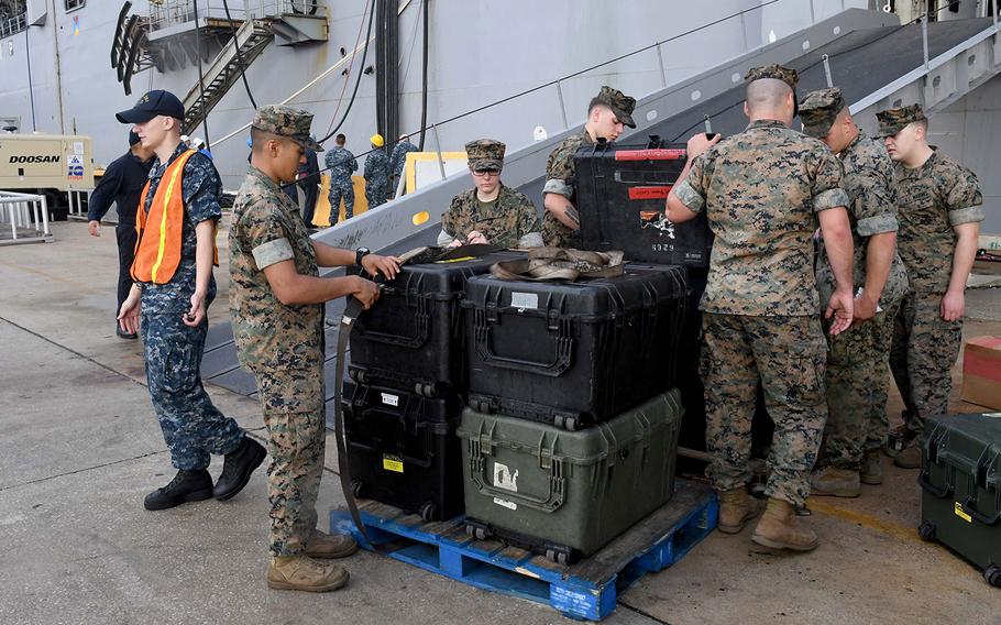 Marines from the 24th Marine Expeditionary Unit load equipment onto the amphibious assault ship USS Iwo Jima in Jacksonville, Florida on Oct. 5, 2016, prior to the ship getting underway ahead of Hurricane Matthew.